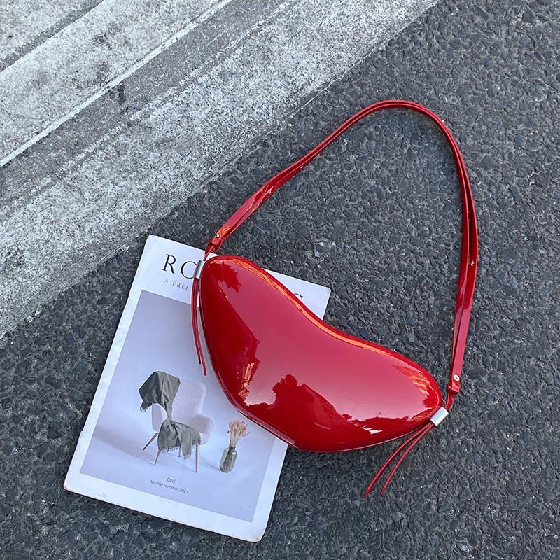 Red handbag on a magazine with a gray pavement background