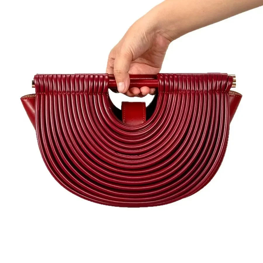 Red handbag held by a hand on a white background