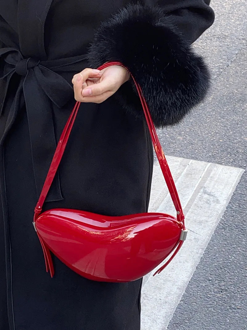 Person holding a red lip-shaped handbag with a black coat.