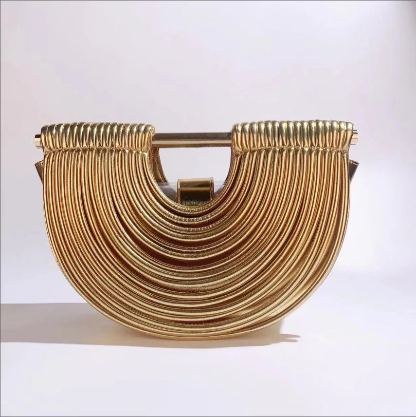 Gold clutch bag with a textured design on a white background
