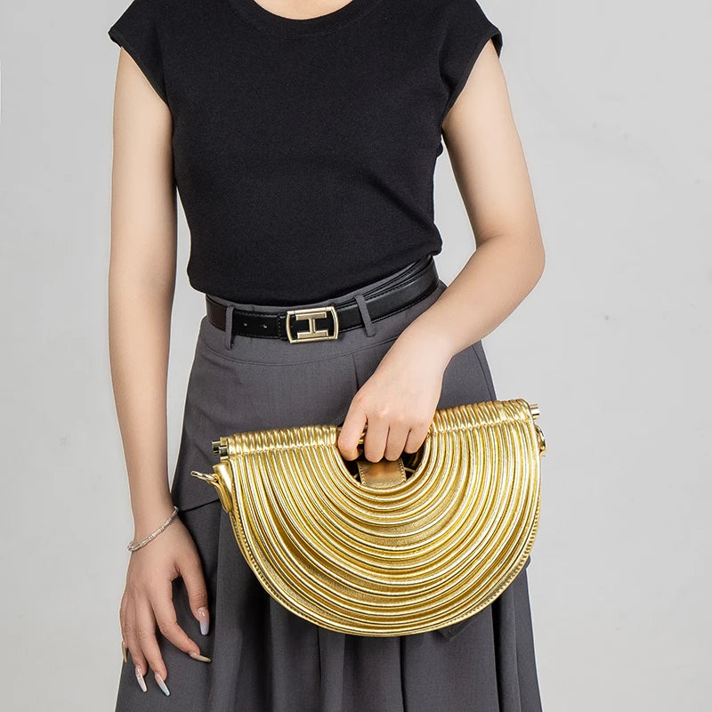 Lady holding a gold handbag against a gray background