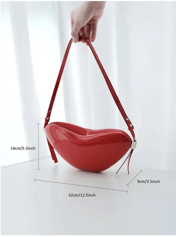Red heart-shaped handbag held by a hand with measurements on a white background