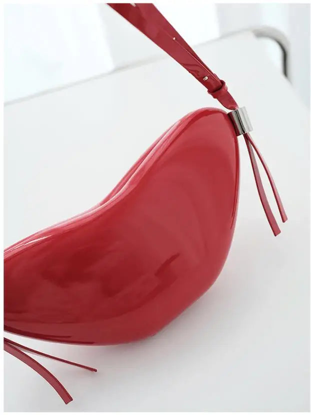 Red handbag with a strap on a white background