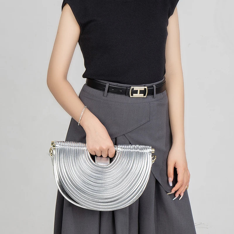 Lady holding a silver handbag against a plain background